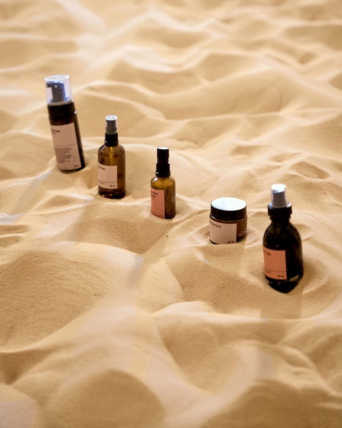 Explore a unique arrangement of beauty products on a textured sand surface, offering a natural aesthetic.